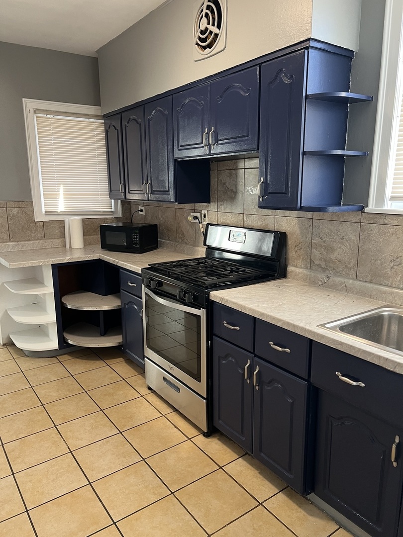 1243 West 96th Street Chicago, IL 60643 - Photo 11 of 13 a kitchen with stainless steel appliances wooden cabinets and a sink