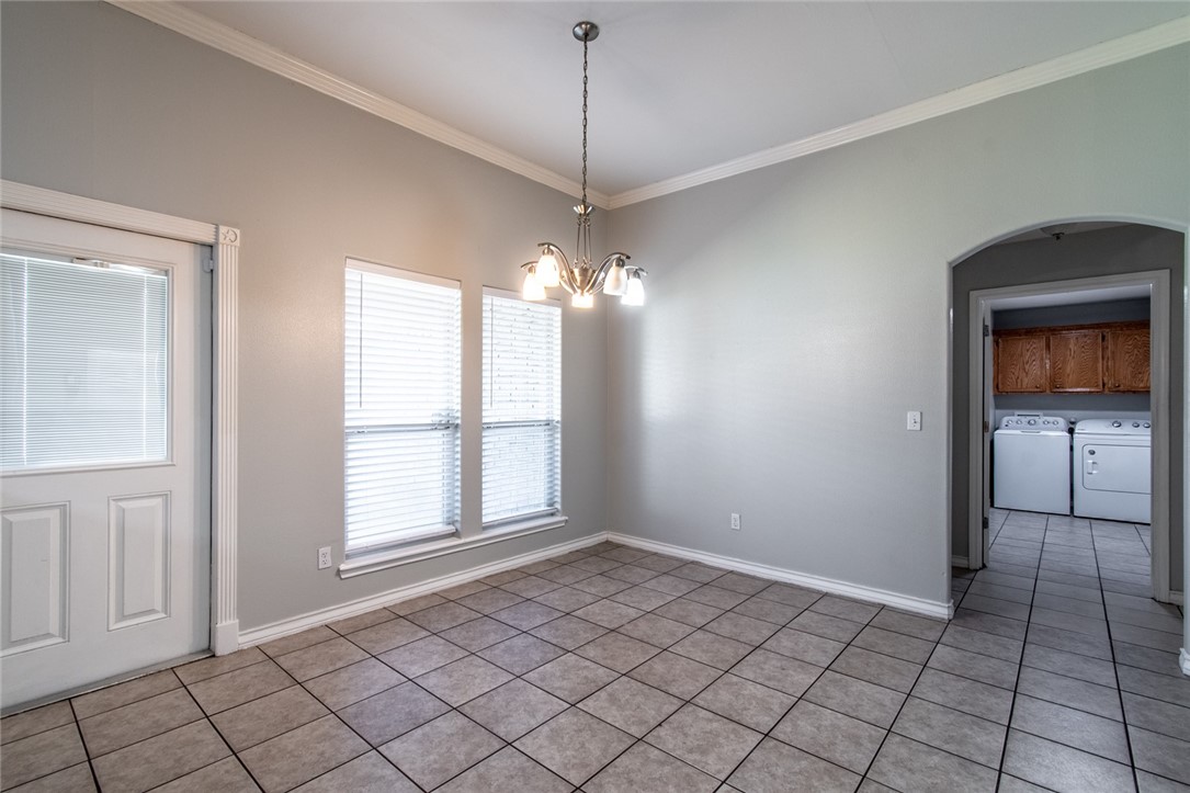 103 Collins Street Odem, TX 78370 - Photo 13 of 32 a view of an empty room with window and chandelier fan