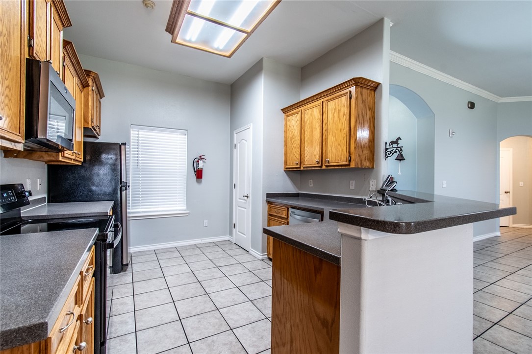 103 Collins Street Odem, TX 78370 - Photo 8 of 32 a kitchen with stainless steel appliances granite countertop a sink stove and cabinets