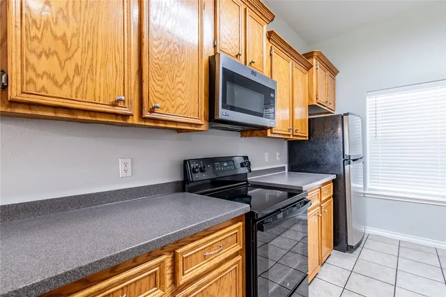 a kitchen with stainless steel appliances granite countertop a stove a microwave and a sink