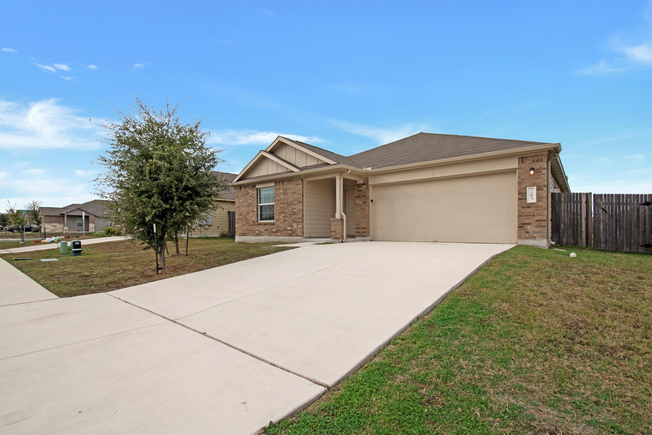 Ranch-style home with brick siding, driveway, an attached garage, and board and batten siding