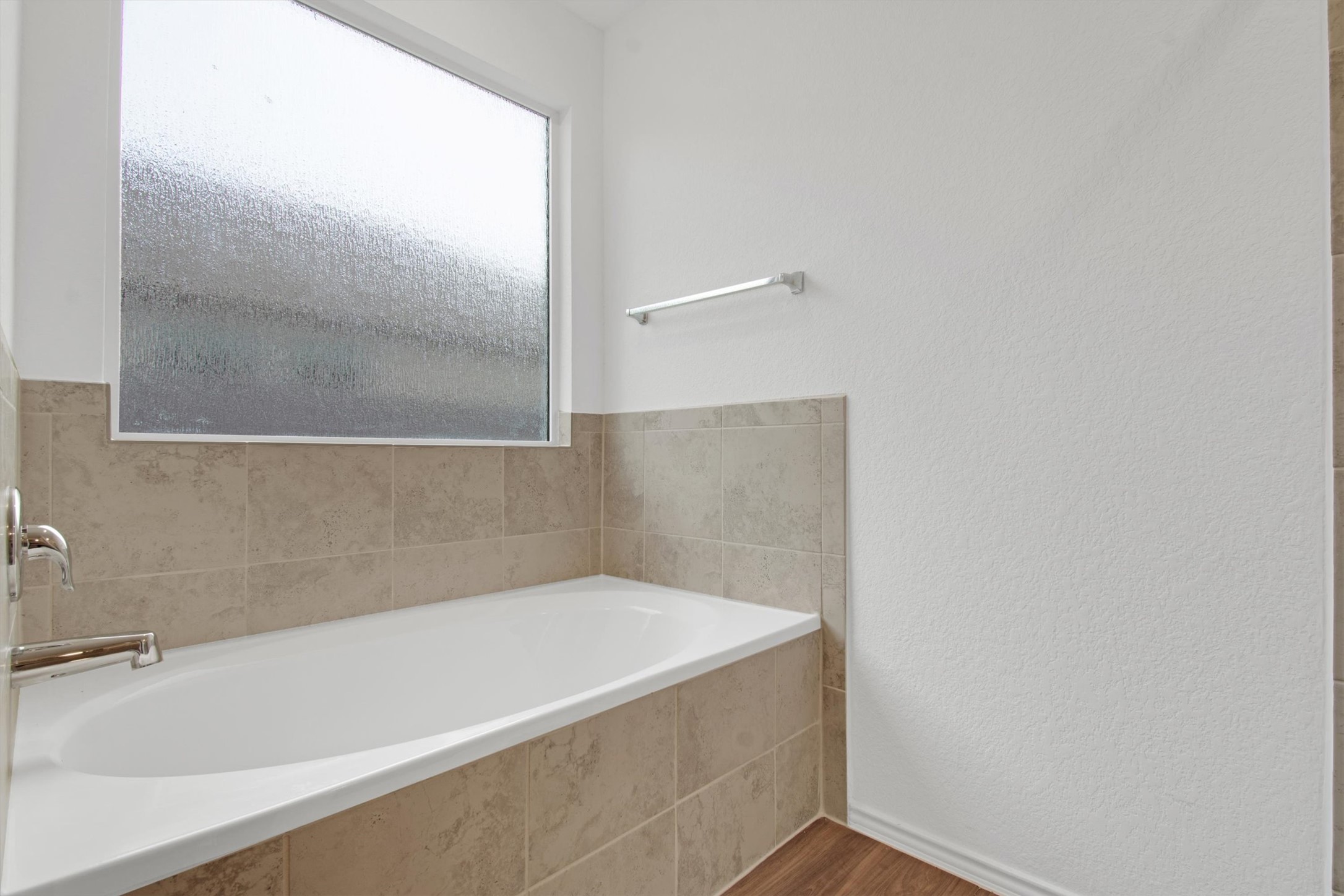 703 Bluejack Way Hutto, TX 78634 - Photo 17 of 19 Full bathroom featuring a garden tub, a textured wall, and dark wood finished floors