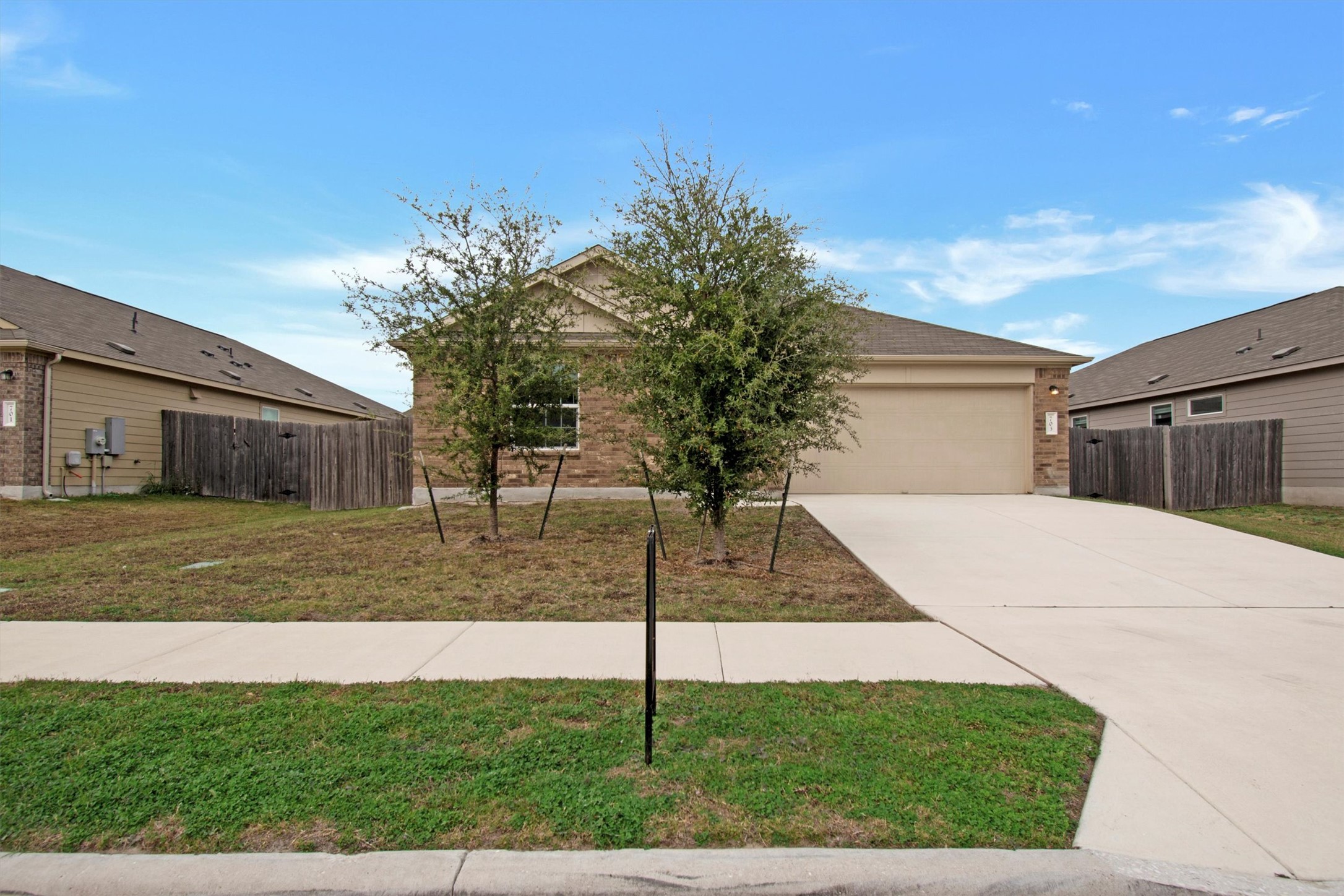 703 Bluejack Way Hutto, TX 78634 - Photo 2 of 19 View of front facade featuring brick siding, concrete driveway, and an attached garage