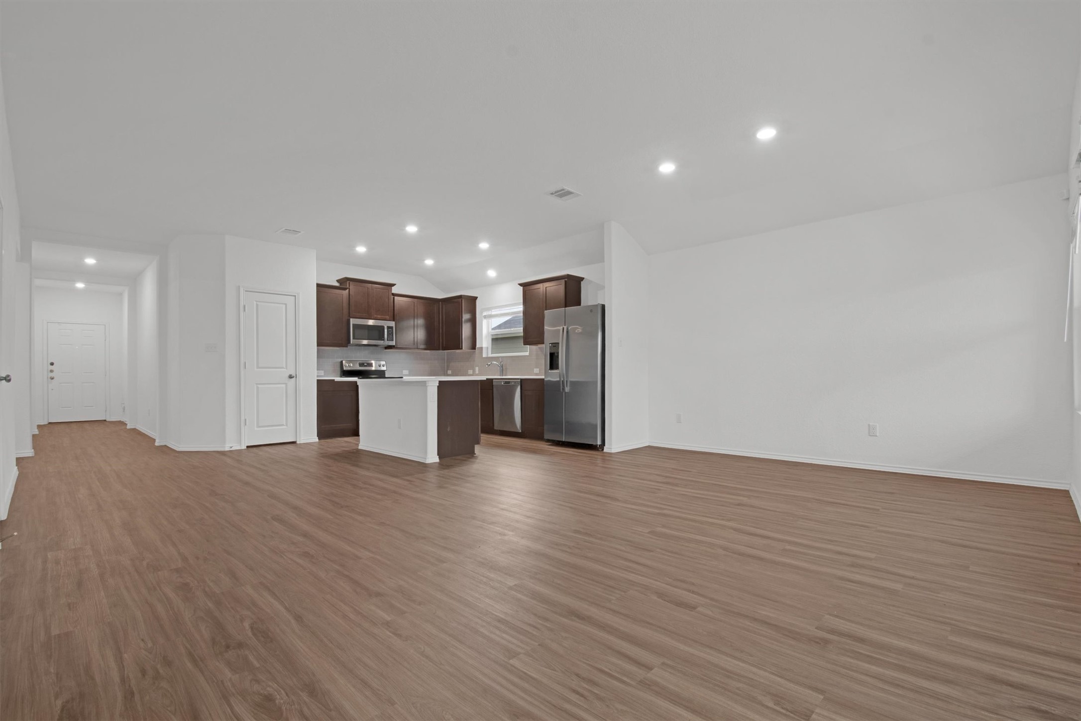703 Bluejack Way Hutto, TX 78634 - Photo 8 of 19 Unfurnished living room with dark wood finished floors and recessed lighting