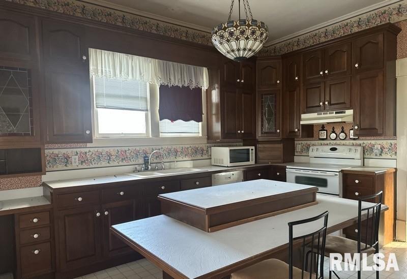 204 North Maple Street Christopher, IL 62822 - Photo 10 of 29 a kitchen with a refrigerator a sink dishwasher a stove and a dining table with wooden floor