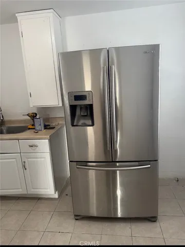 a metallic refrigerator freezer sitting in a kitchen