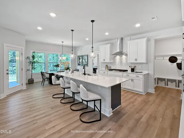 a kitchen with stainless steel appliances granite countertop a dining table chairs and kitchen view