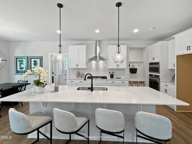 a kitchen with kitchen island granite countertop a white cabinets and refrigerator