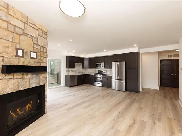 a large kitchen with stainless steel appliances granite countertop a stove and a refrigerator