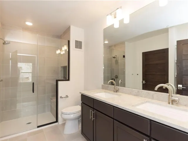 a bathroom with a granite countertop sink a toilet and a mirror