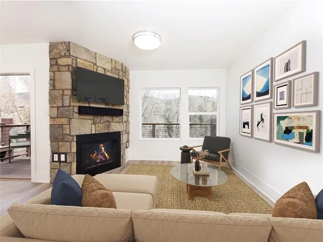 a living room with furniture a fireplace and a flat screen tv