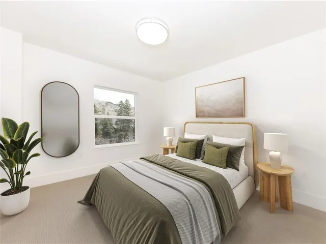 a bedroom with a bed and a potted plant