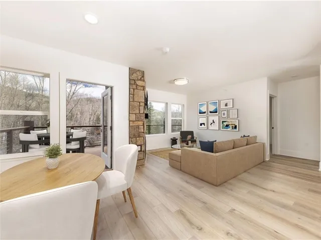 a living room with furniture large window and a table
