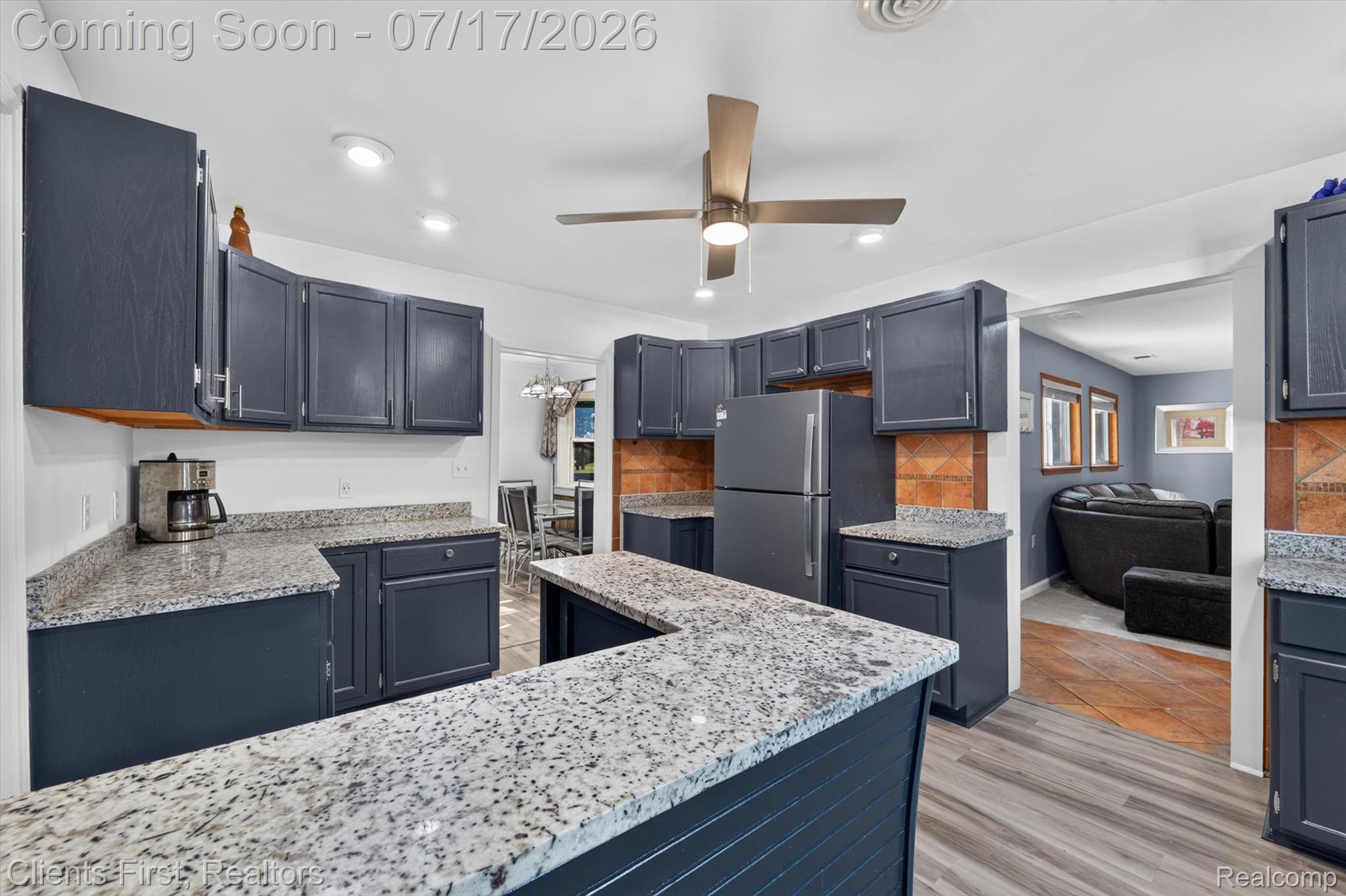 36852 Chase Street Romulus, MI 48174 - Photo 8 of 40 Kitchen featuring dark cabinetry, speckled countertops, tile backsplash, and a ceiling fan