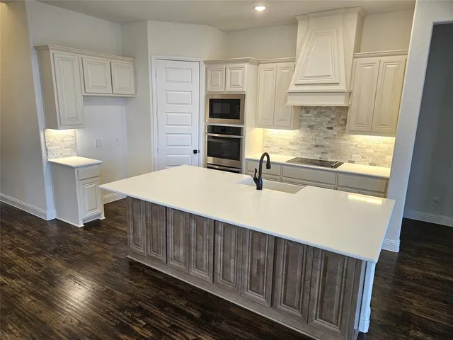 a kitchen with a sink and a stove top oven