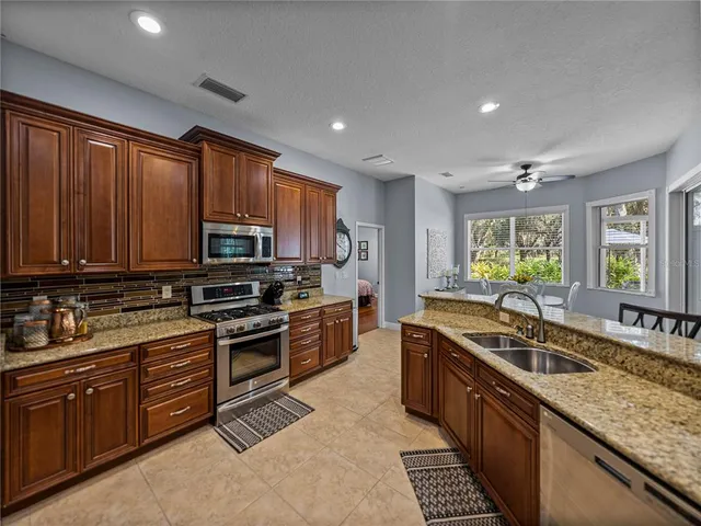 a kitchen with stainless steel appliances granite countertop a sink stove and cabinets