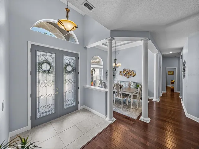 a view of a hallway with wooden floor windows a fireplace and chandelier