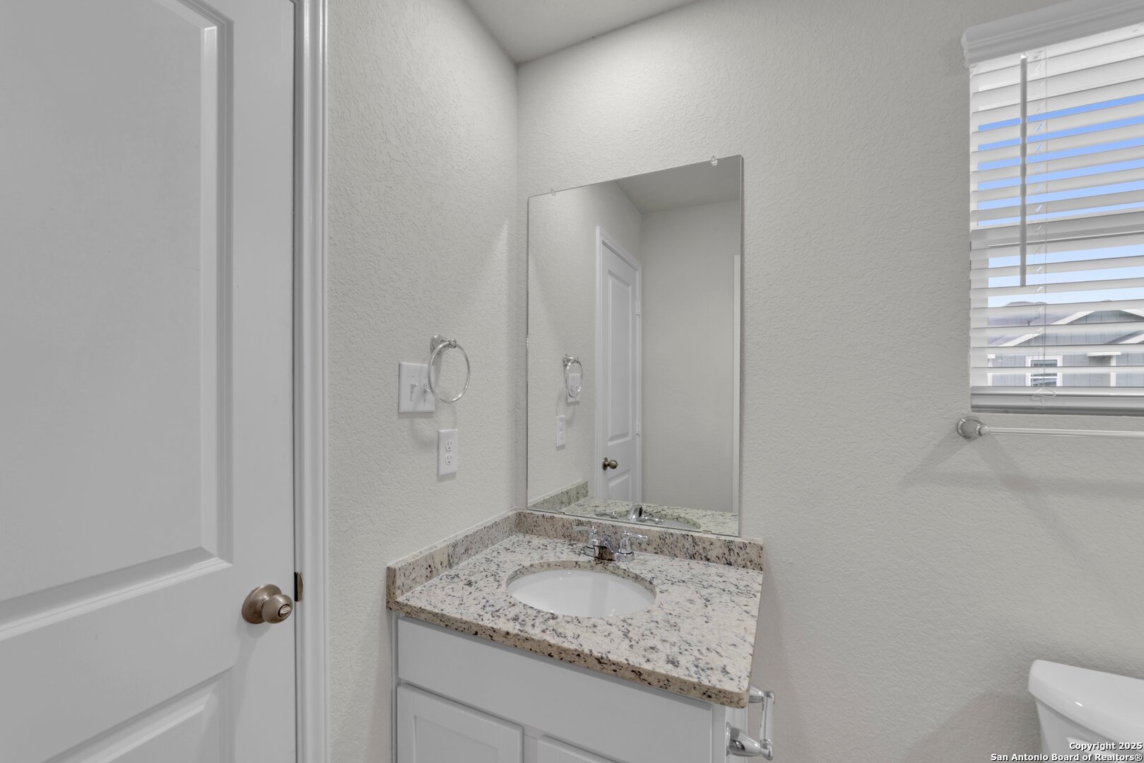 8711 Key Windy Way, Unit 2 Converse, TX 78109 - Photo 16 of 22 a bathroom with a granite countertop sink and mirror with toilet