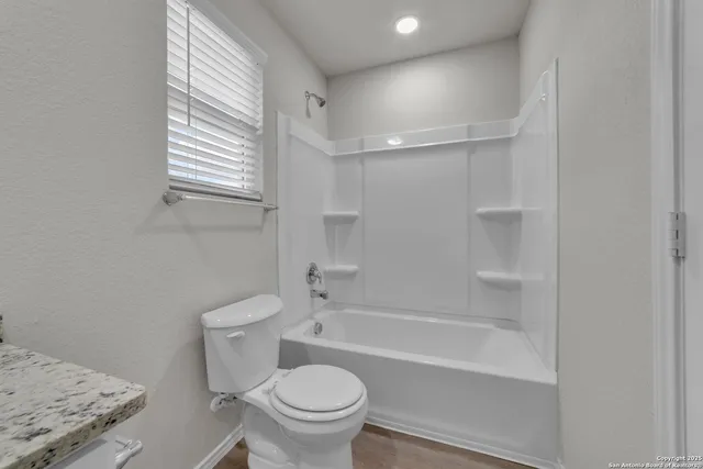 a bathroom with a granite countertop toilet a sink and bathtub