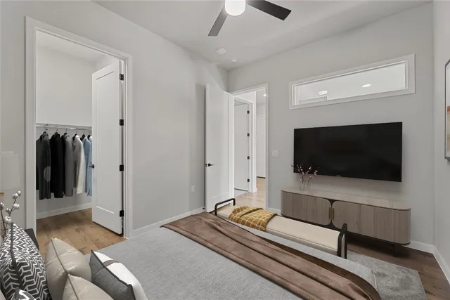 a bedroom with a bed and a flat tv screen on wall