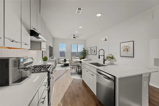 a kitchen with sink stove and cabinets