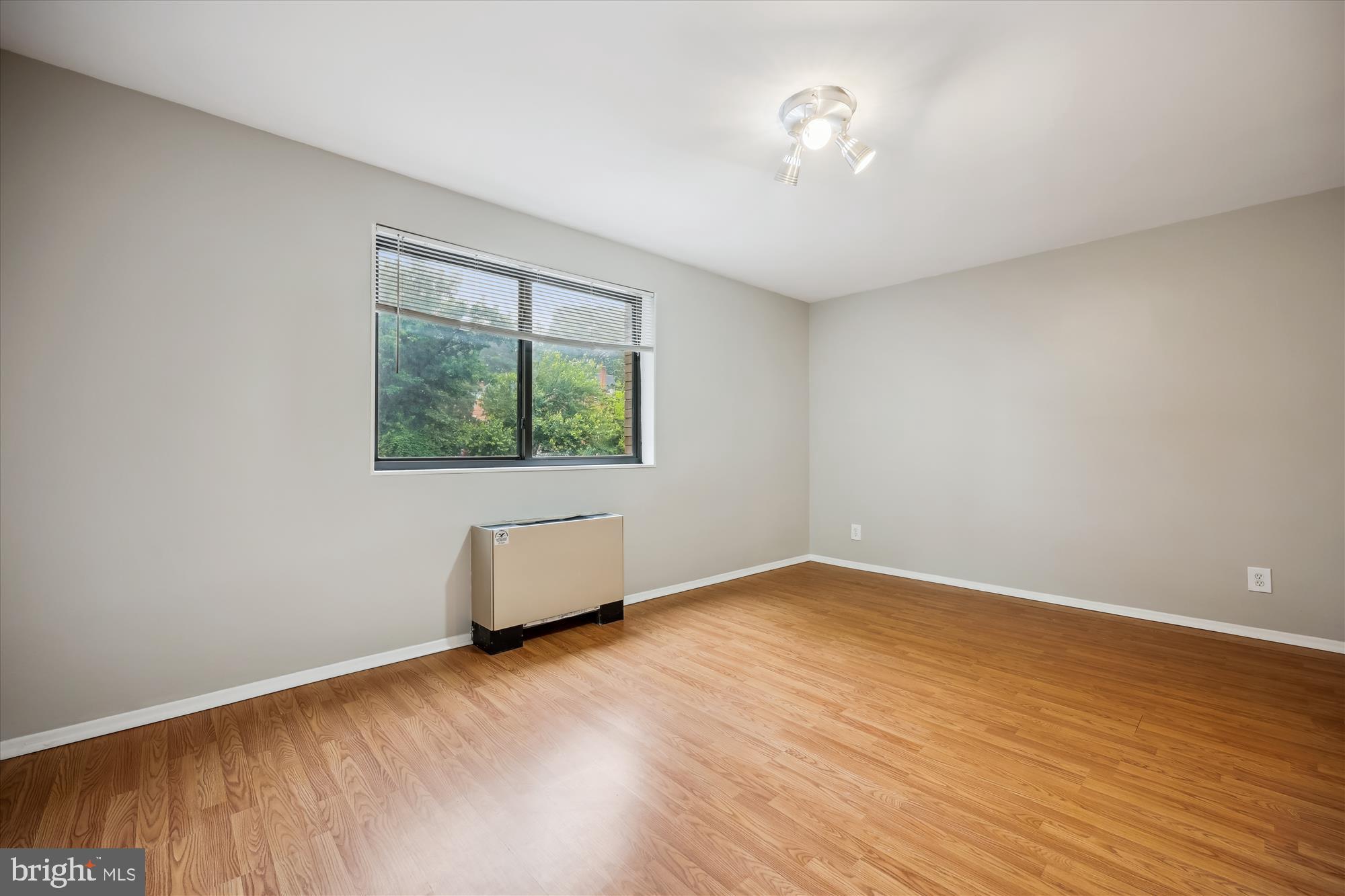 8601 Manchester Road, Unit 319 Silver Spring, MD 20901 - Photo 16 of 70 an empty room with wooden floor and windows