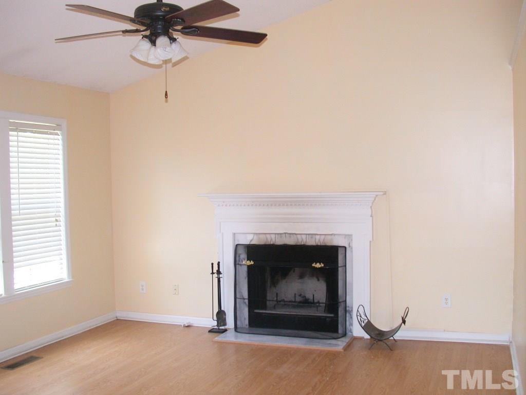 2124 Ruddy Road Raleigh, NC 27616 - Photo 7 of 20 a living room with a fireplace and a ceiling fan
