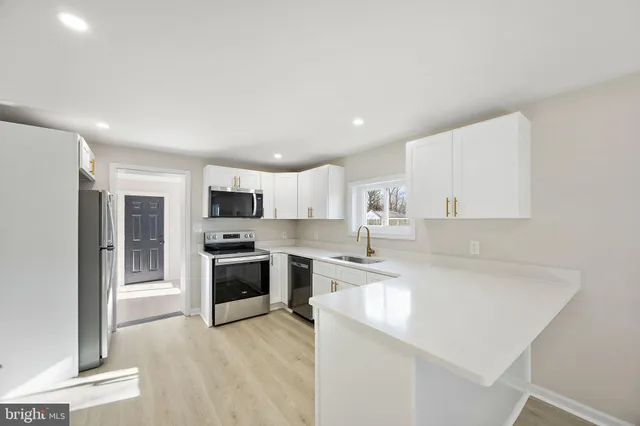 a kitchen with stainless steel appliances granite countertop a stove top oven a sink and a refrigerator