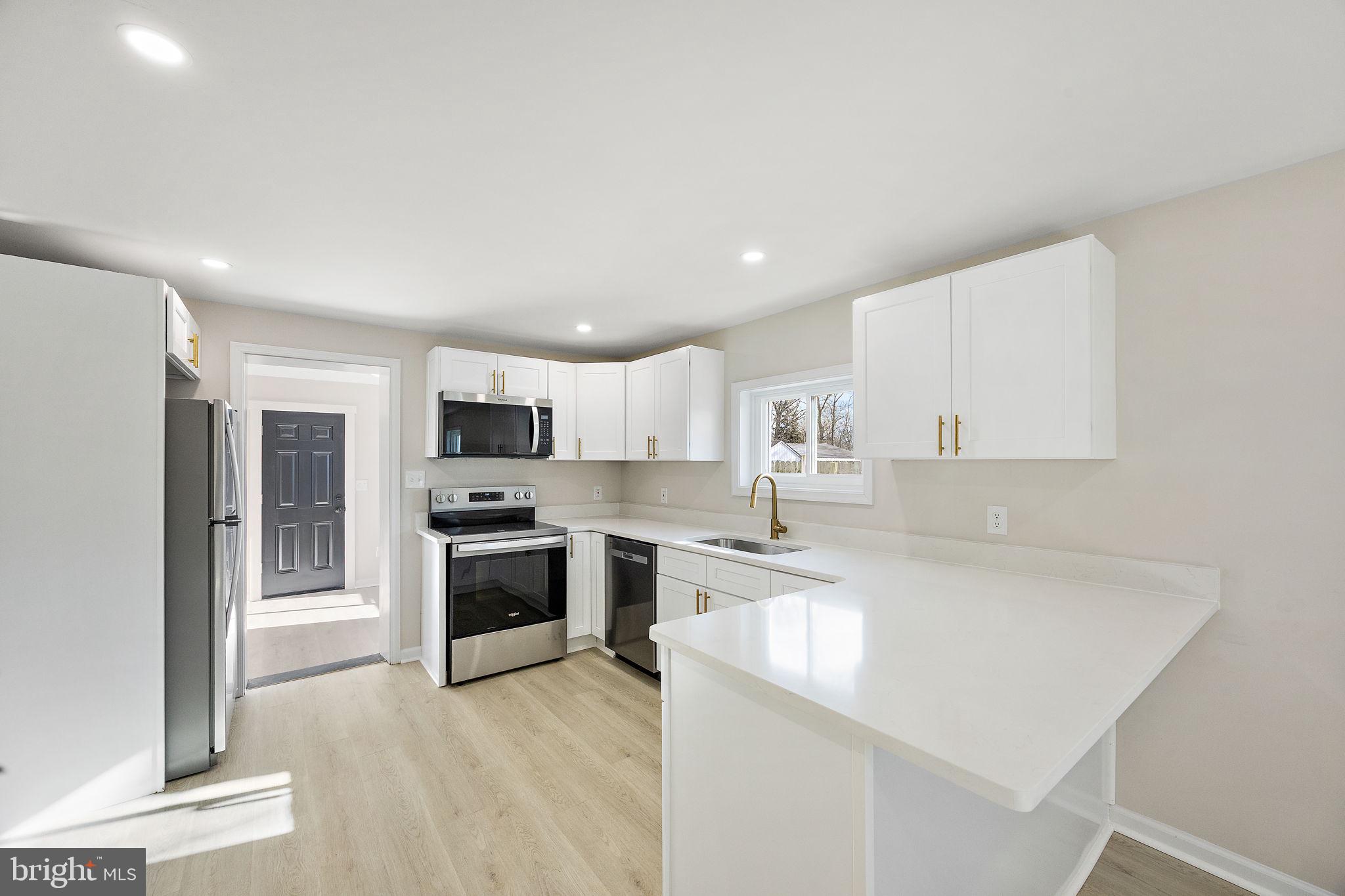 2109 Ferncroft Avenue Upper Chichester, PA 19061 - Photo 3 of 25 a kitchen with stainless steel appliances granite countertop a stove top oven a sink and a refrigerator