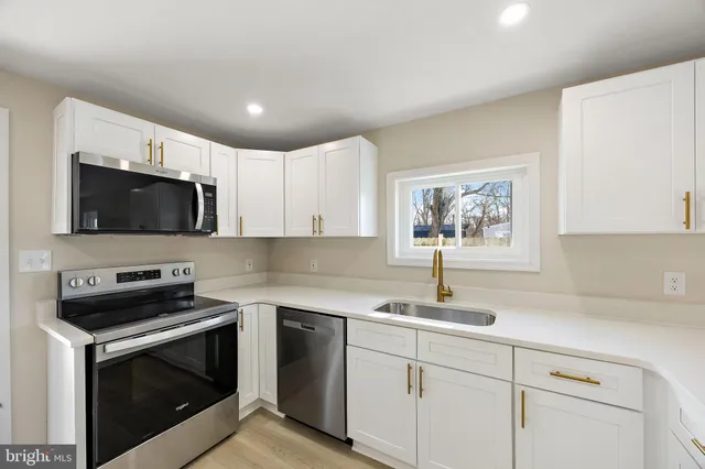 a kitchen with stainless steel appliances a stove microwave and sink