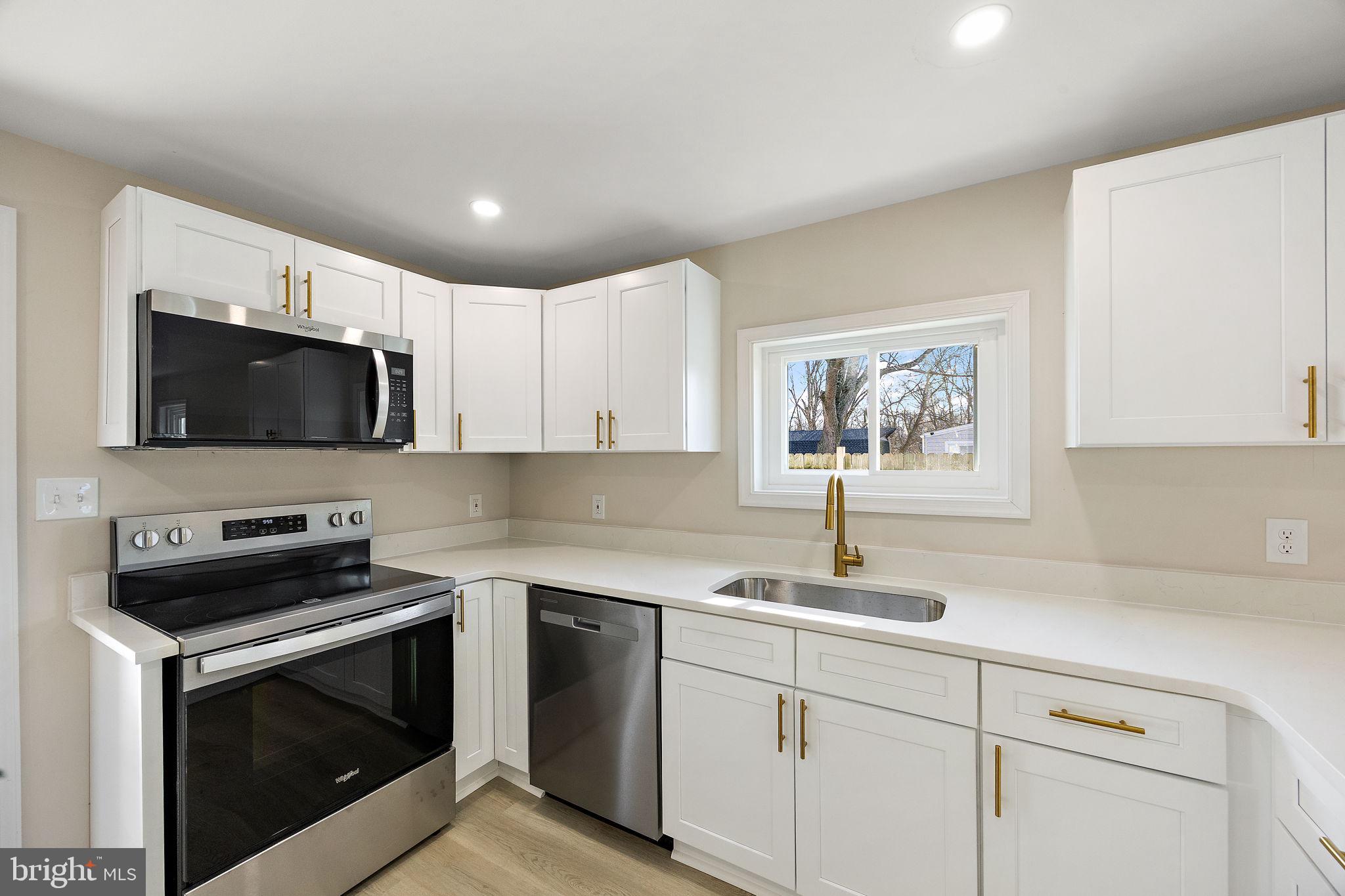 2109 Ferncroft Avenue Upper Chichester, PA 19061 - Photo 4 of 25 a kitchen with stainless steel appliances a stove microwave and sink