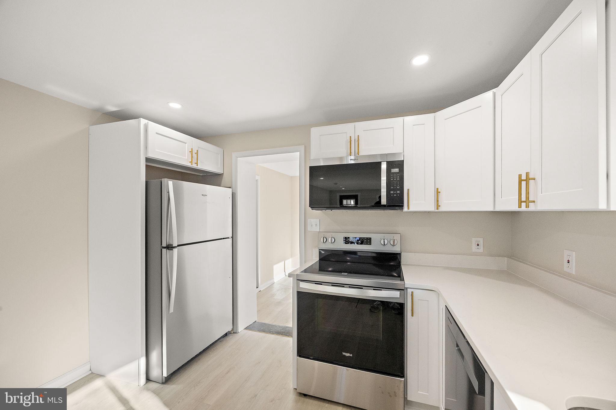 2109 Ferncroft Avenue Upper Chichester, PA 19061 - Photo 5 of 25 a kitchen with a refrigerator stove and white cabinets