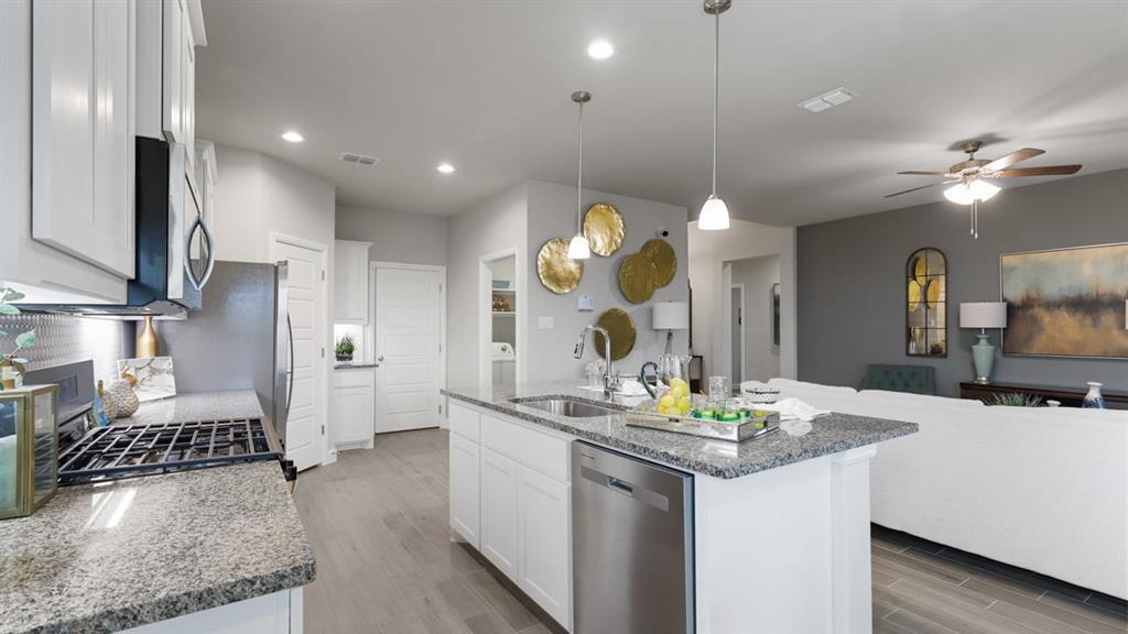 717 Bushman Drive Aledo, TX 76008 - Photo 6 of 40 a kitchen with kitchen island granite countertop a sink a stove and a refrigerator