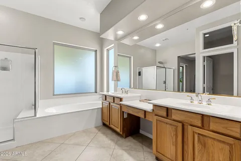 a large bathroom with a large tub sink vanity and granite