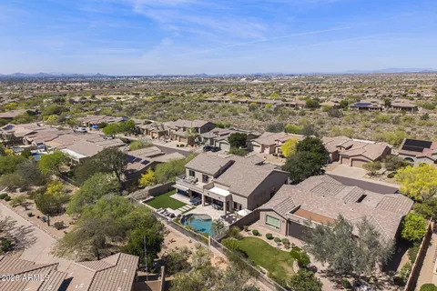 an aerial view of residential houses with outdoor space and trees