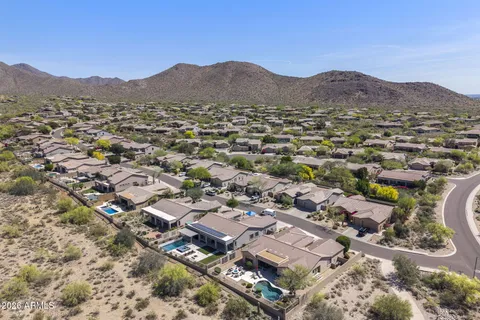 an aerial view of residential houses with outdoor space and trees
