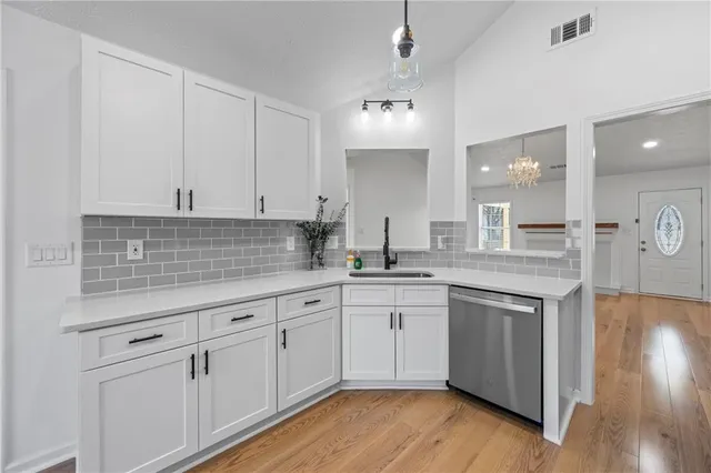 a spacious bedroom with a large bed and a chandelier