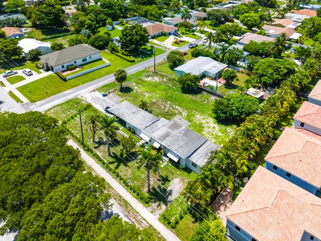 an aerial view of a residential houses with yard