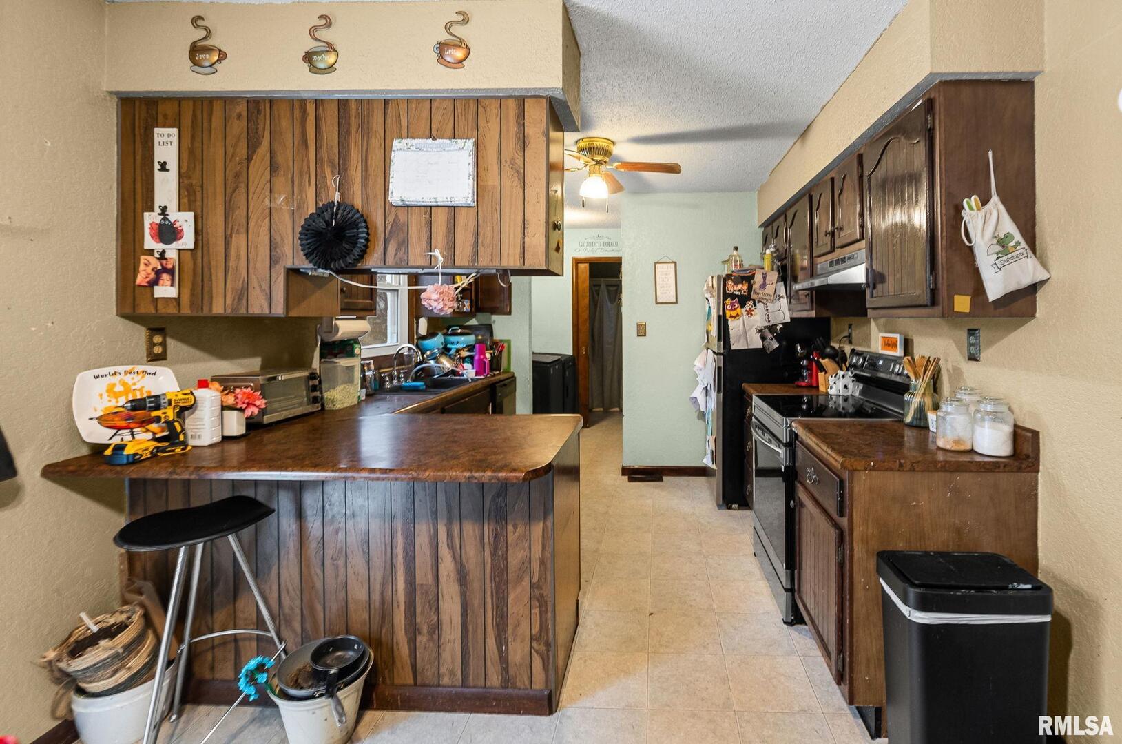 103 Middleton Street Iuka, IL 62849 - Photo 15 of 27 a kitchen with stainless steel appliances kitchen island granite countertop a table chairs in it and wooden floors