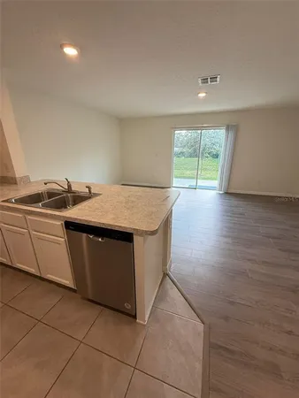 a kitchen with granite countertop a refrigerator and a sink