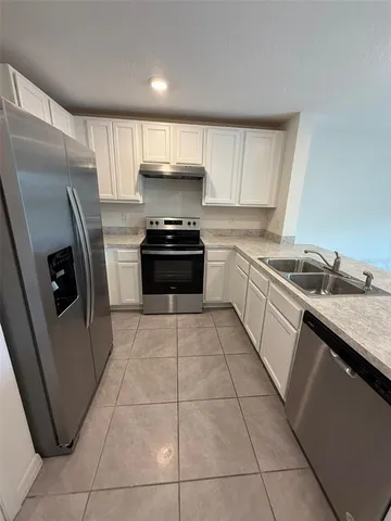 a view of a kitchen with kitchen island a sink wooden floor and a counter top space