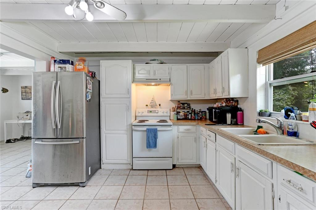 4391 Little Hickory Road Bonita Springs, FL 34134 - Photo 11 of 35 a kitchen with a sink a refrigerator and cabinets
