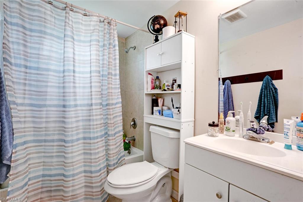 4391 Little Hickory Road Bonita Springs, FL 34134 - Photo 17 of 35 a bathroom with a sink a toilet and shower curtain