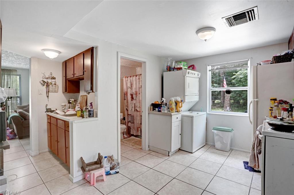 4391 Little Hickory Road Bonita Springs, FL 34134 - Photo 21 of 35 a kitchen with a refrigerator and white cabinets