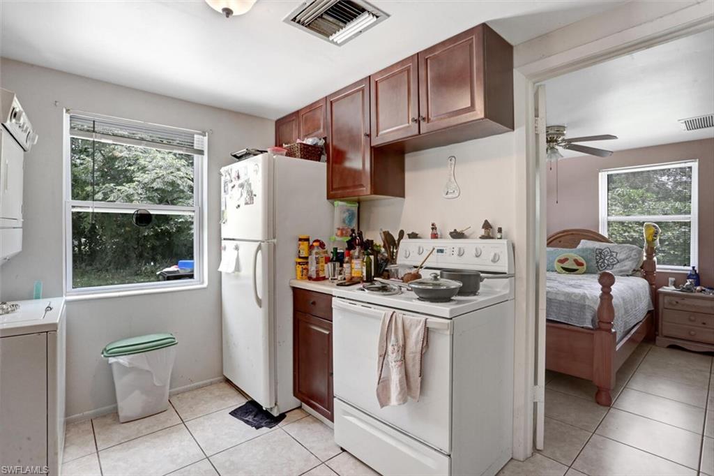 4391 Little Hickory Road Bonita Springs, FL 34134 - Photo 22 of 35 a kitchen with stainless steel appliances granite countertop a refrigerator sink and stove