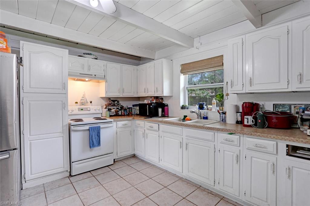 4391 Little Hickory Road Bonita Springs, FL 34134 - Photo 10 of 35 a kitchen with white cabinets and white appliances