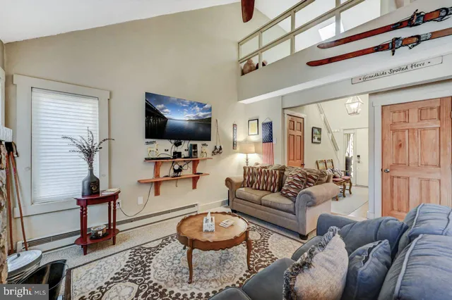 a dining room with wooden floor a chandelier a wooden table and chairs