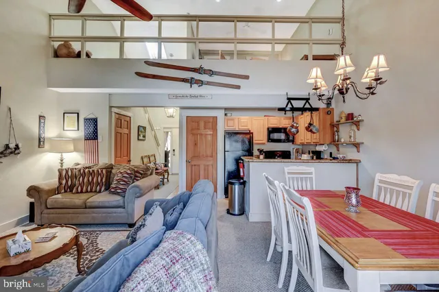 a view of a dining room with furniture a chandelier and wooden floor