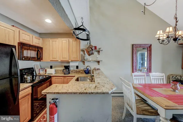 a kitchen with a sink dishwasher a dining table and chairs with wooden floor