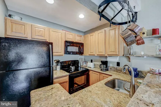 a kitchen with stainless steel appliances granite countertop a sink and a wooden cabinets